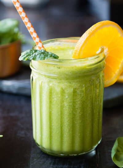 High-protein green smoothie garnished with an orange slice