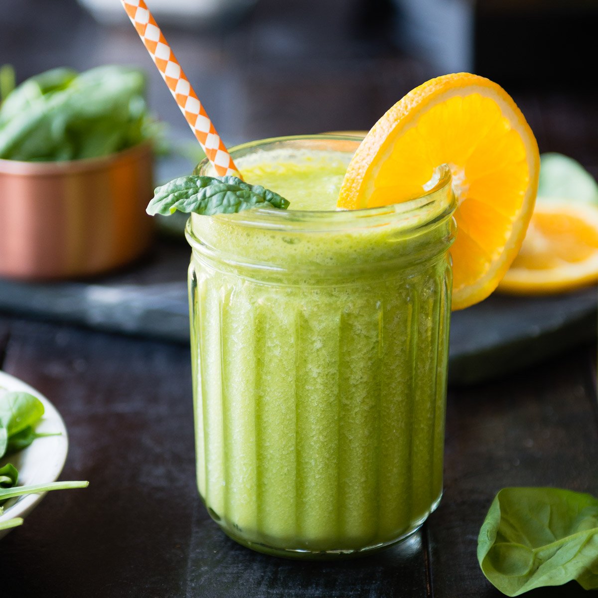 High-protein green smoothie garnished with an orange slice