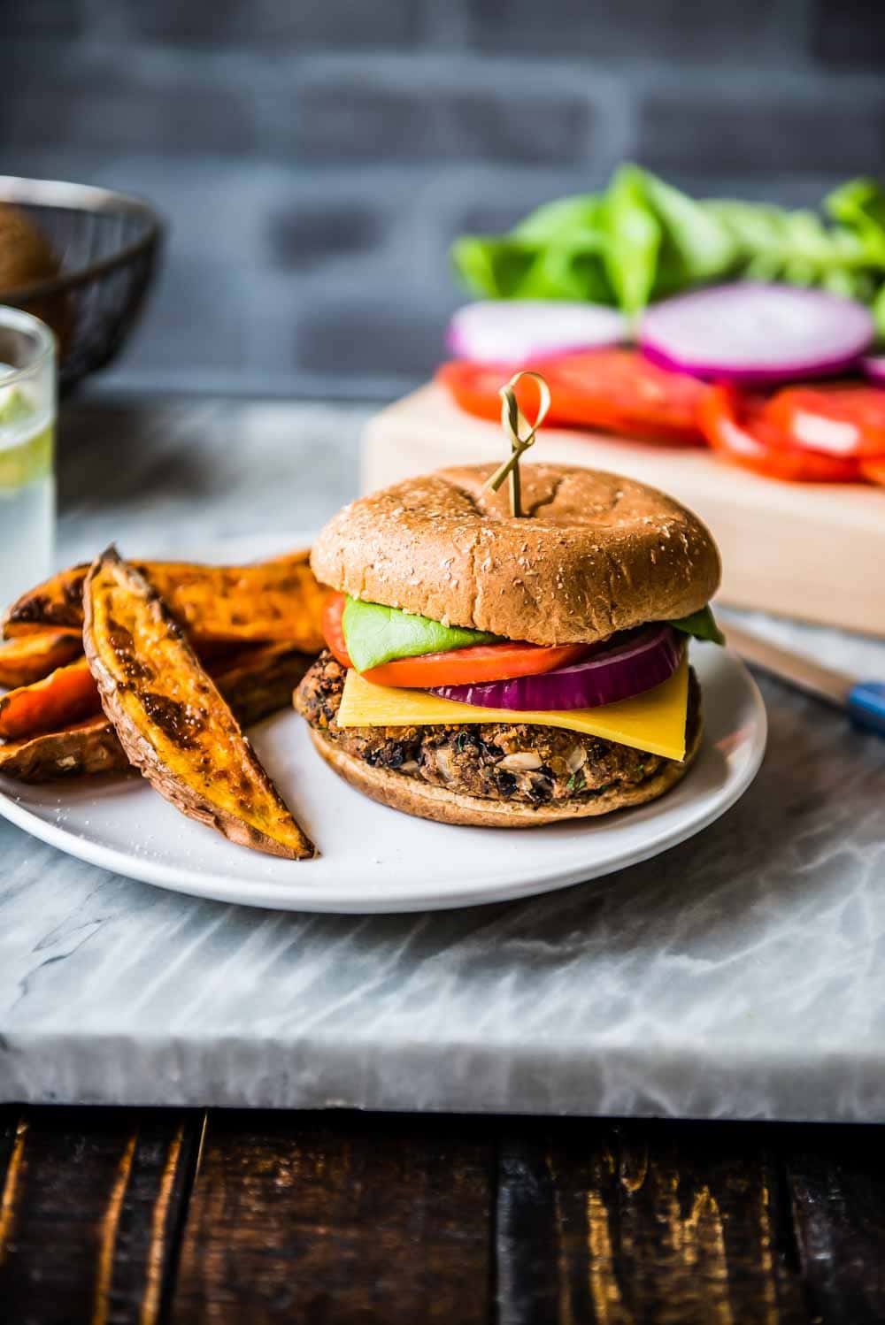 simply plated black bean burger with sweet potato wedge fries.
