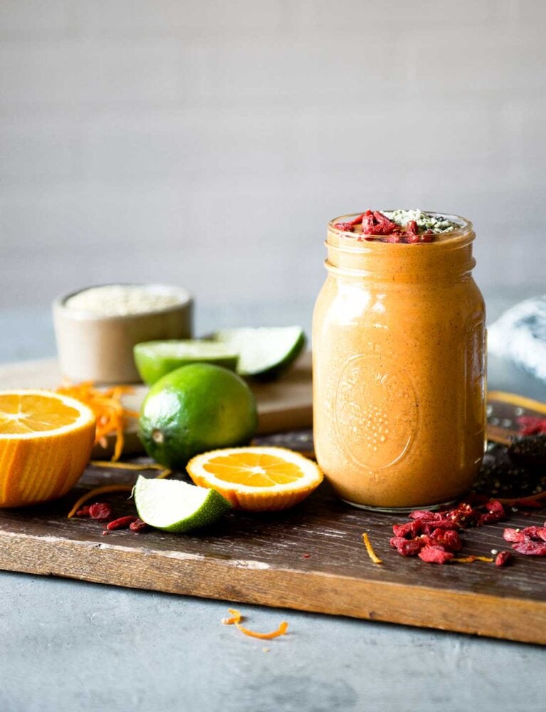 Blended orange smoothie with goji berrries.