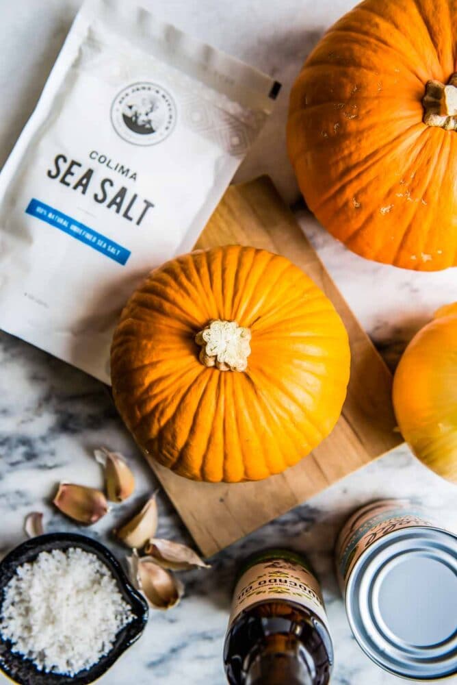 whole pie pumpkin next to a bag of Colima Sea Salt, ready to be roasted for this pumpkin soup