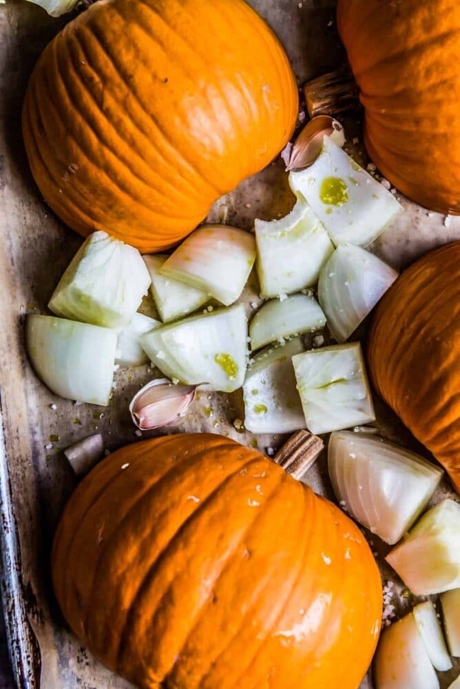 a few halved pumpkins and sliced onions, ready to go into a pumpkin soup