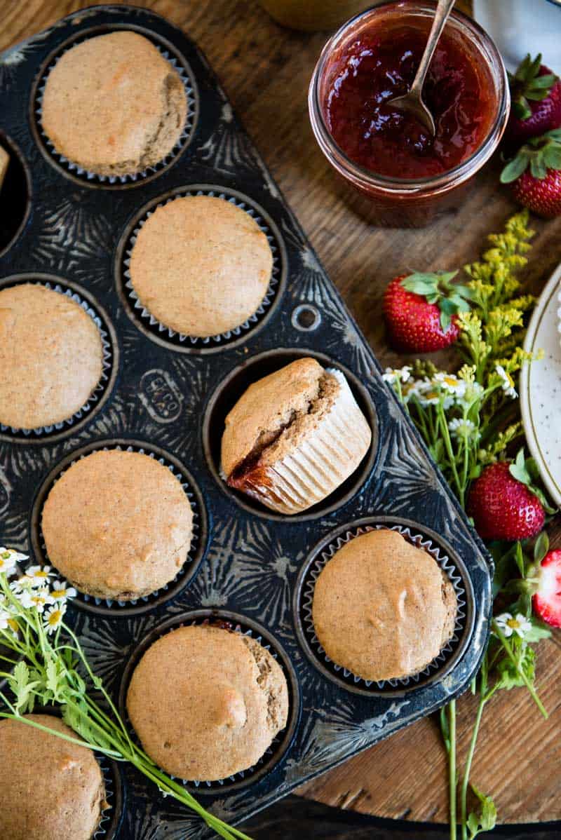 a pan full of strawberry jam-filled vegan muffins