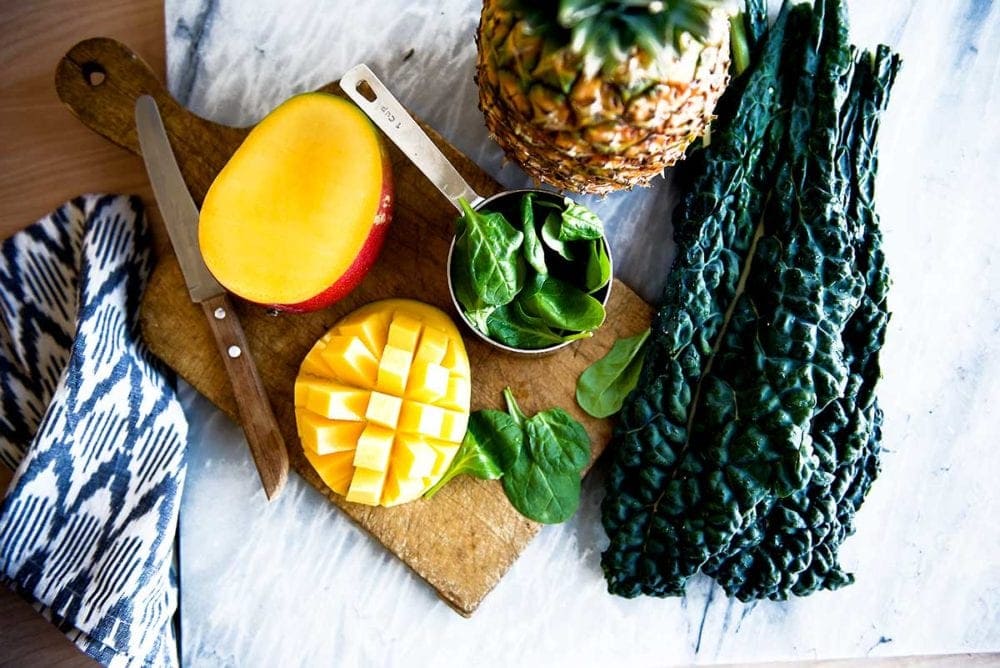 Plant-based whole food ingredients on a cutting board to prepare the smoothie recipe.