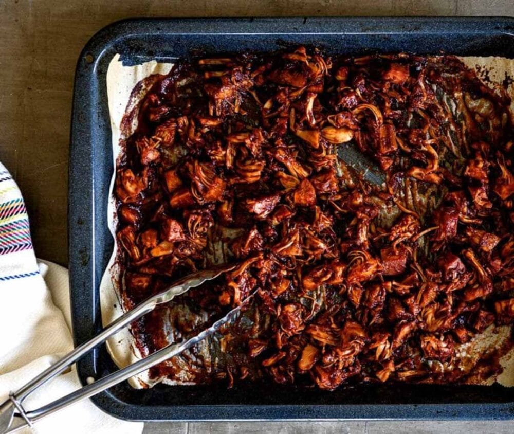 bbq sauce on jackfruit in roasting dish.