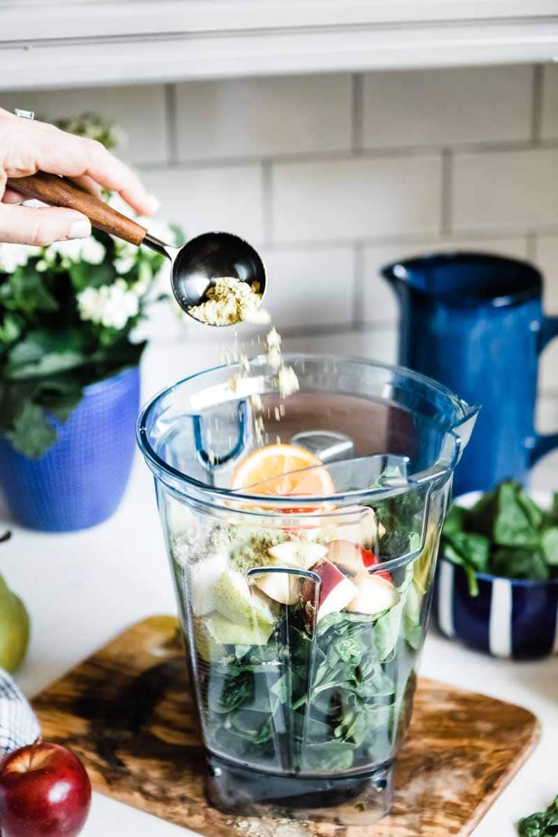 Plant-based protein powder added to glowing green smoothie