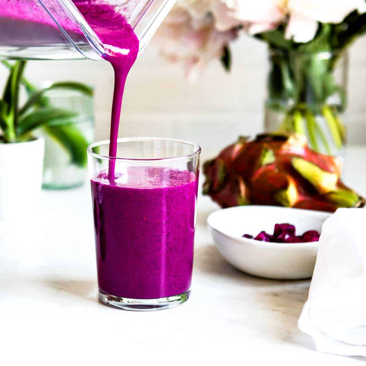 Immune boosting smoothie recipe getting poured into a clear glass.