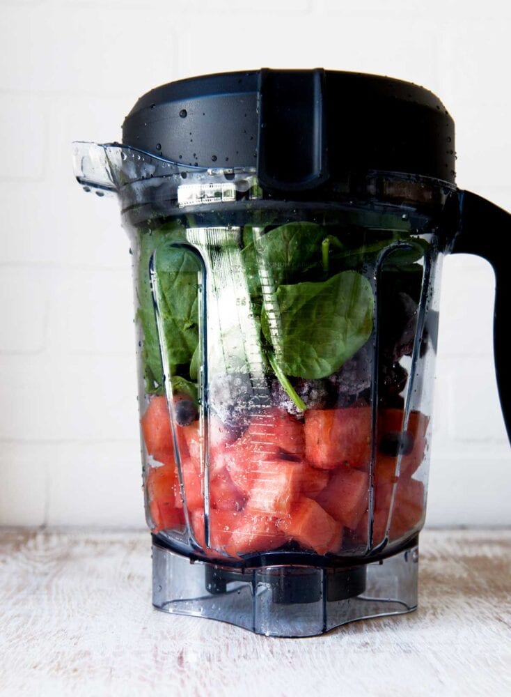 Fresh ingredients layered in blender jar before blending.