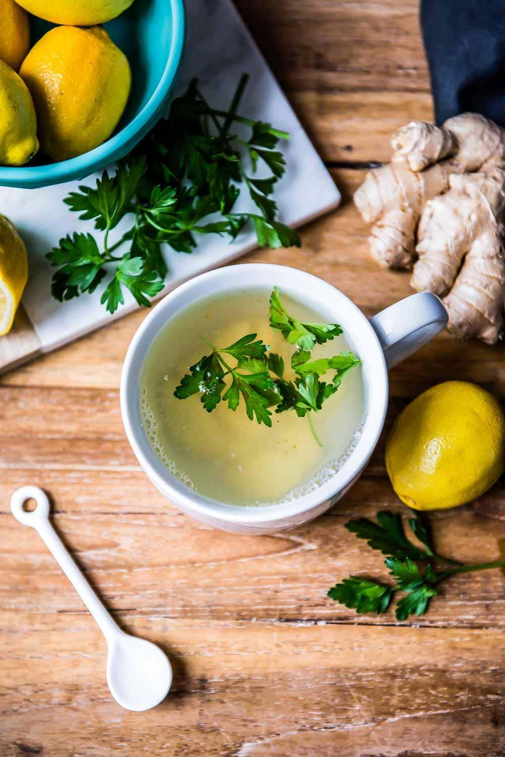 overhead shot of the best detox tea recipe, complete with cleansing tea ingredients like lemon, ginger, and parsley