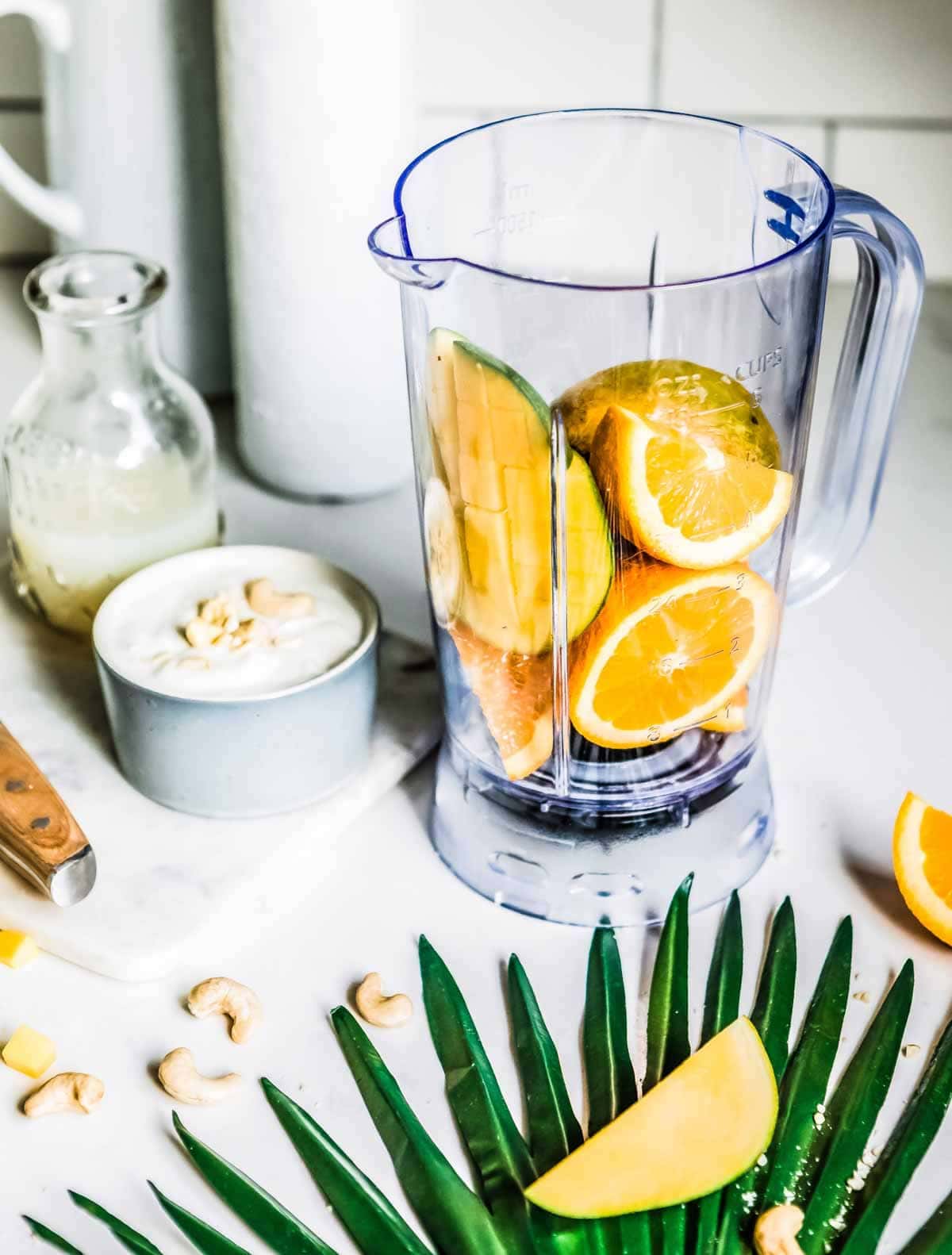 ingredients for a mango smoothie recipe inside a blender container.