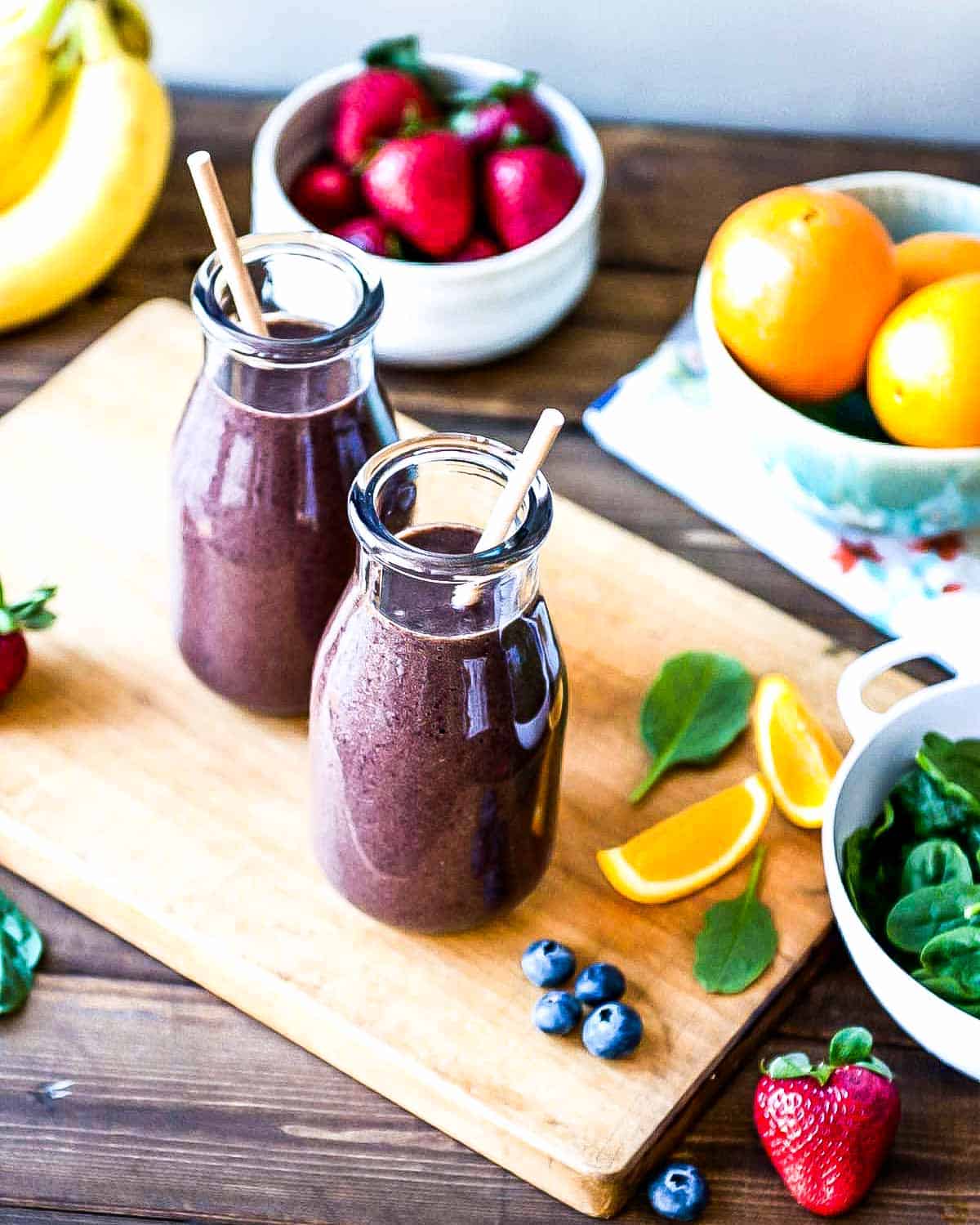 Berry smoothie in 2 glasses with paper straws.