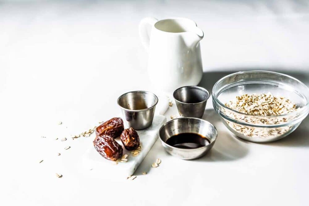 Ingredients in white and metal bowls to make CInnamon Date Smoothie.