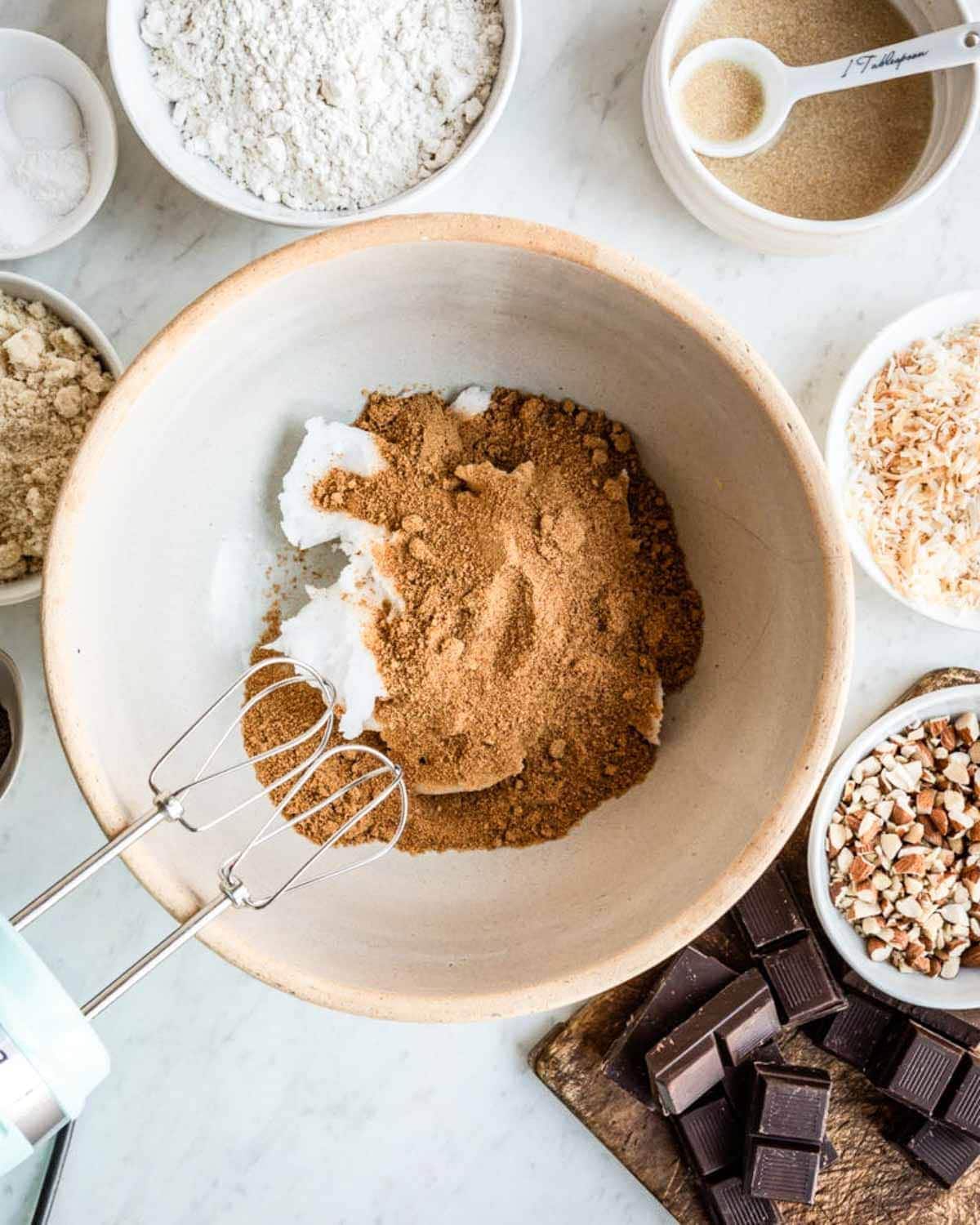 mixing coconut oil and coconut sugar with a hand mixer.