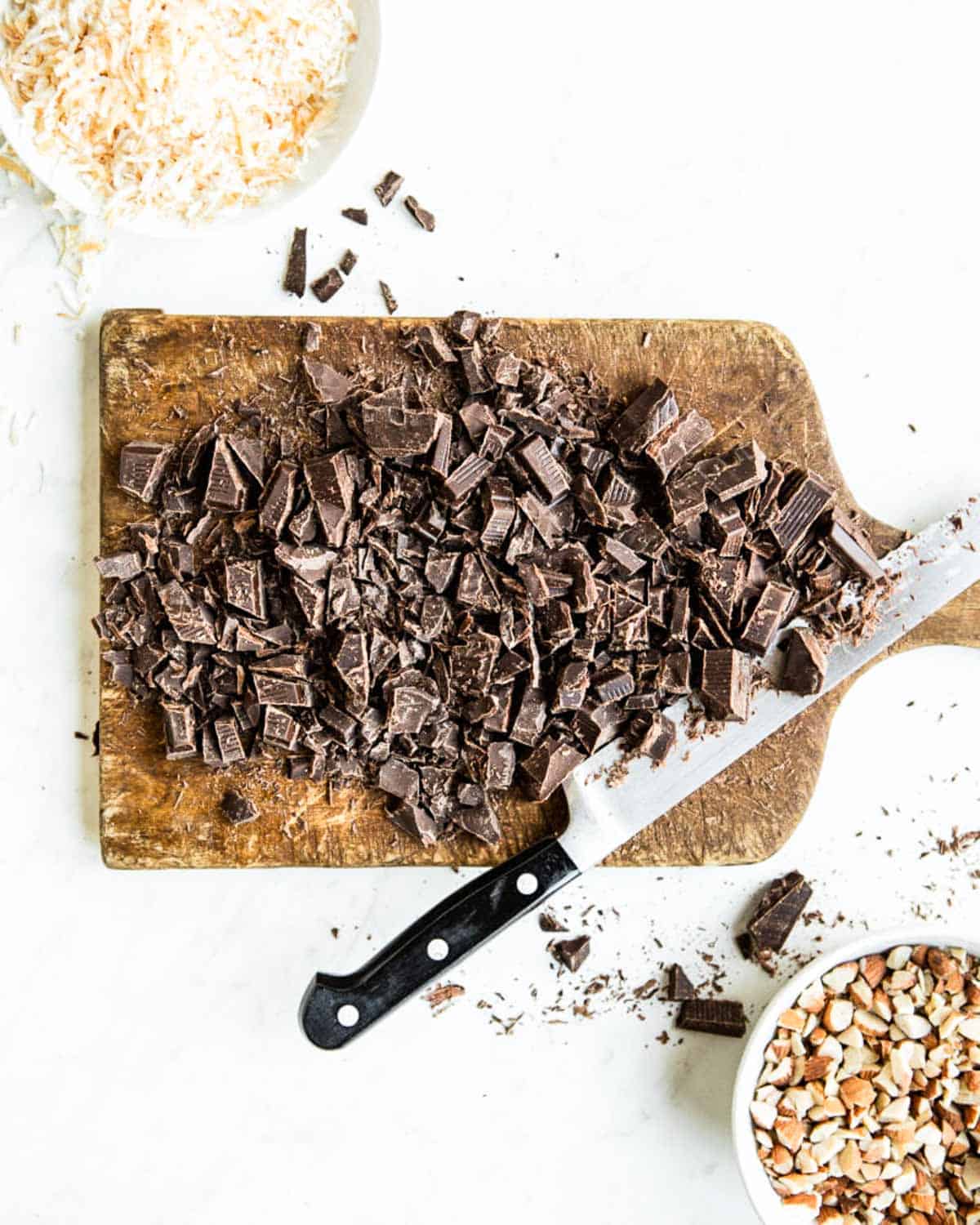 cutting board full of chopped chocolate and knife.