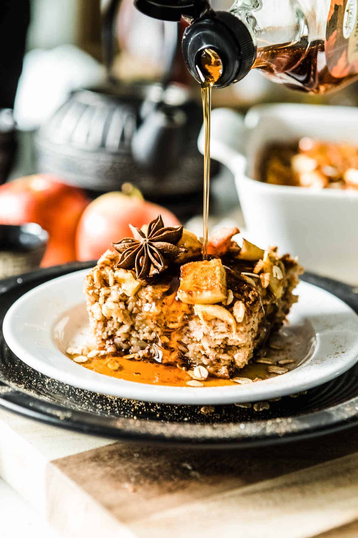 Delicious maple syrup being poured over A serving of Apple cinnamon baked oatmeal.