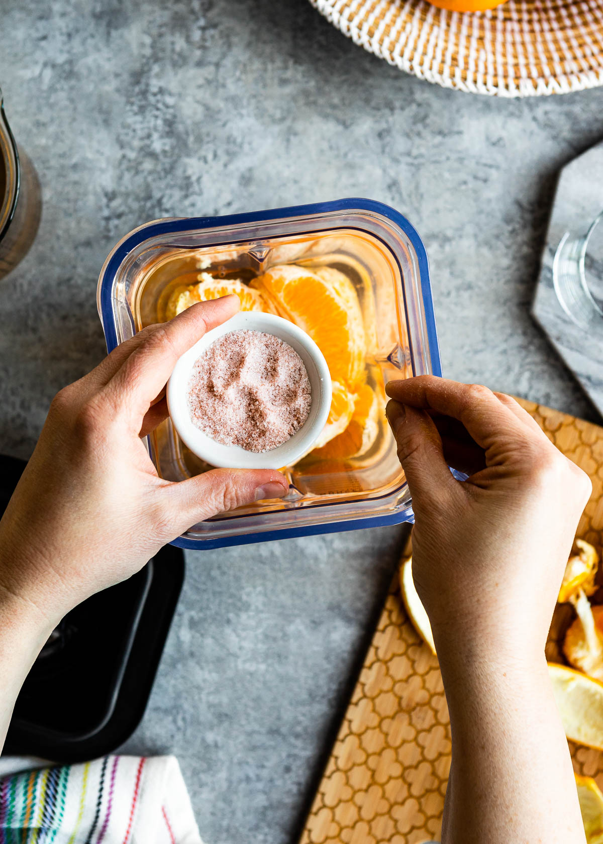 Sprinkling a pinch of Himalayan sea salt on oranges and coconut water in a blender