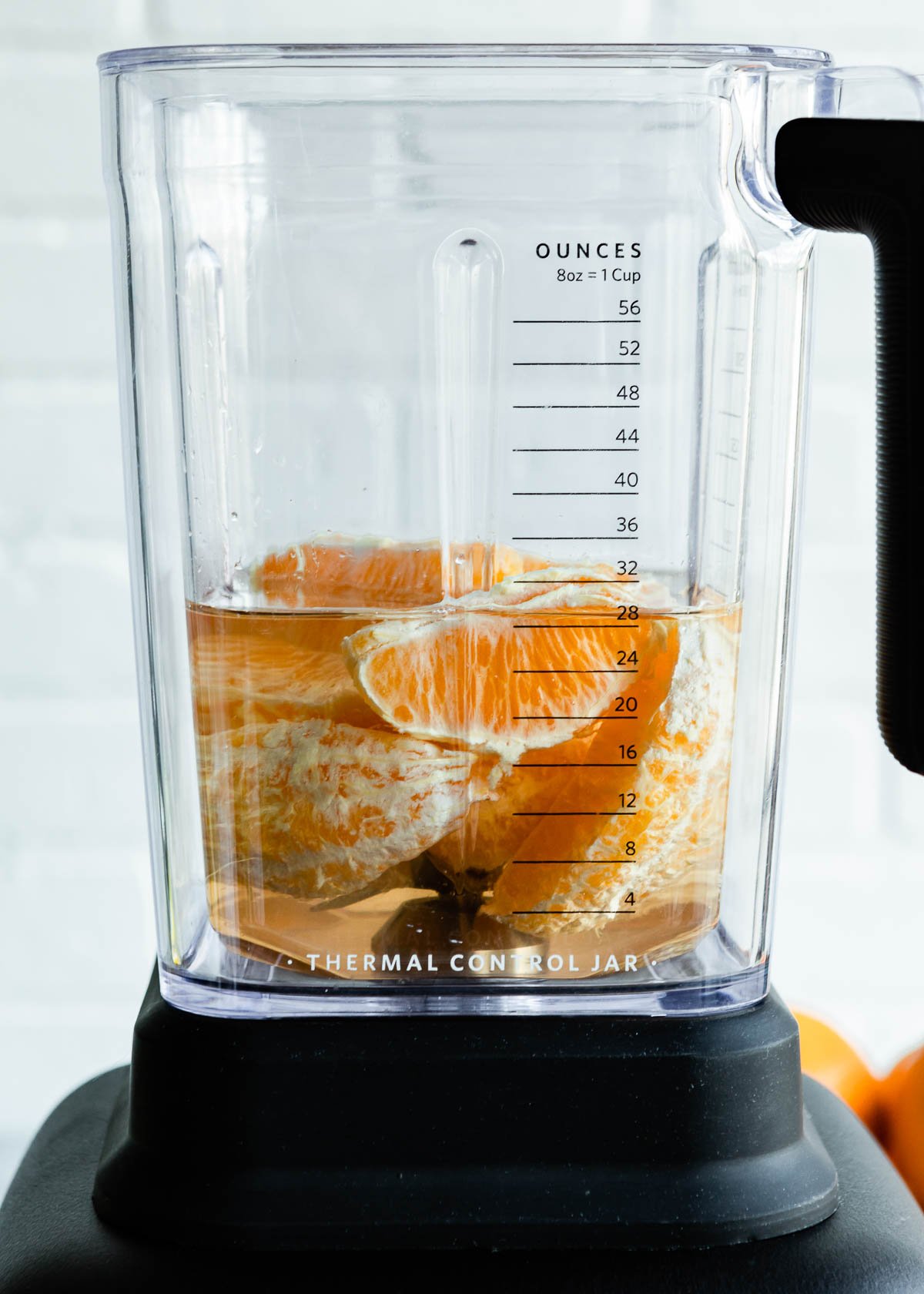 Blender filled with oranges and coconut water