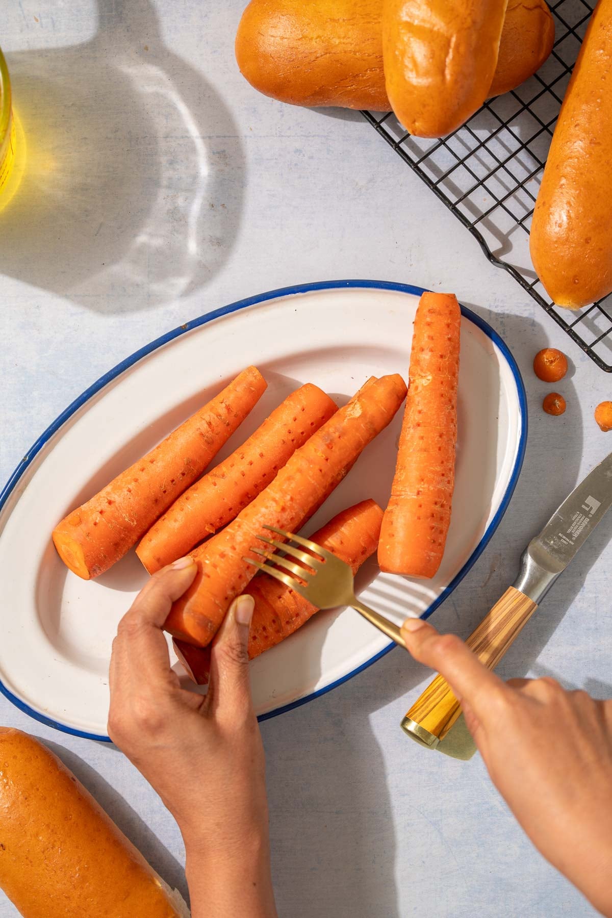 Using a fork to poke holes in and prep the carrots