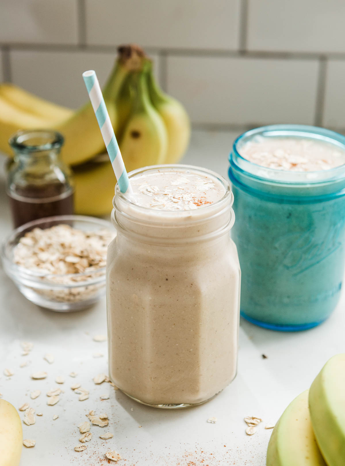 Refreshing banana oatmeal smoothie in a glass with a straw.