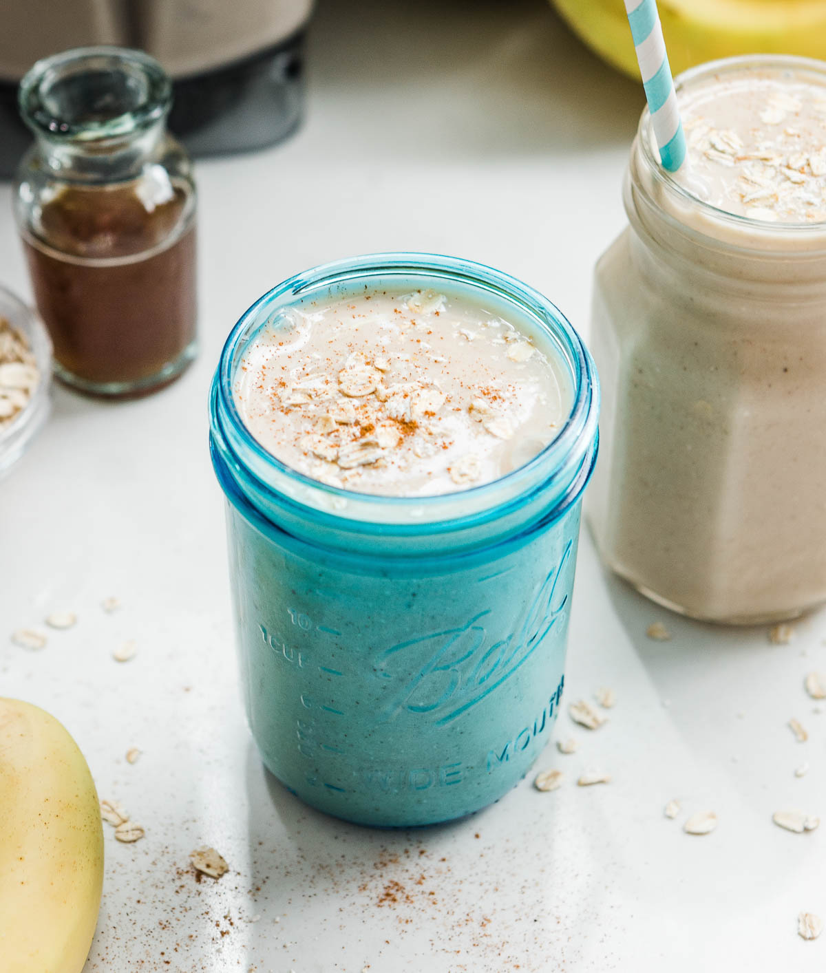 A freshly blended banana oatmeal smoothie topped with oats.