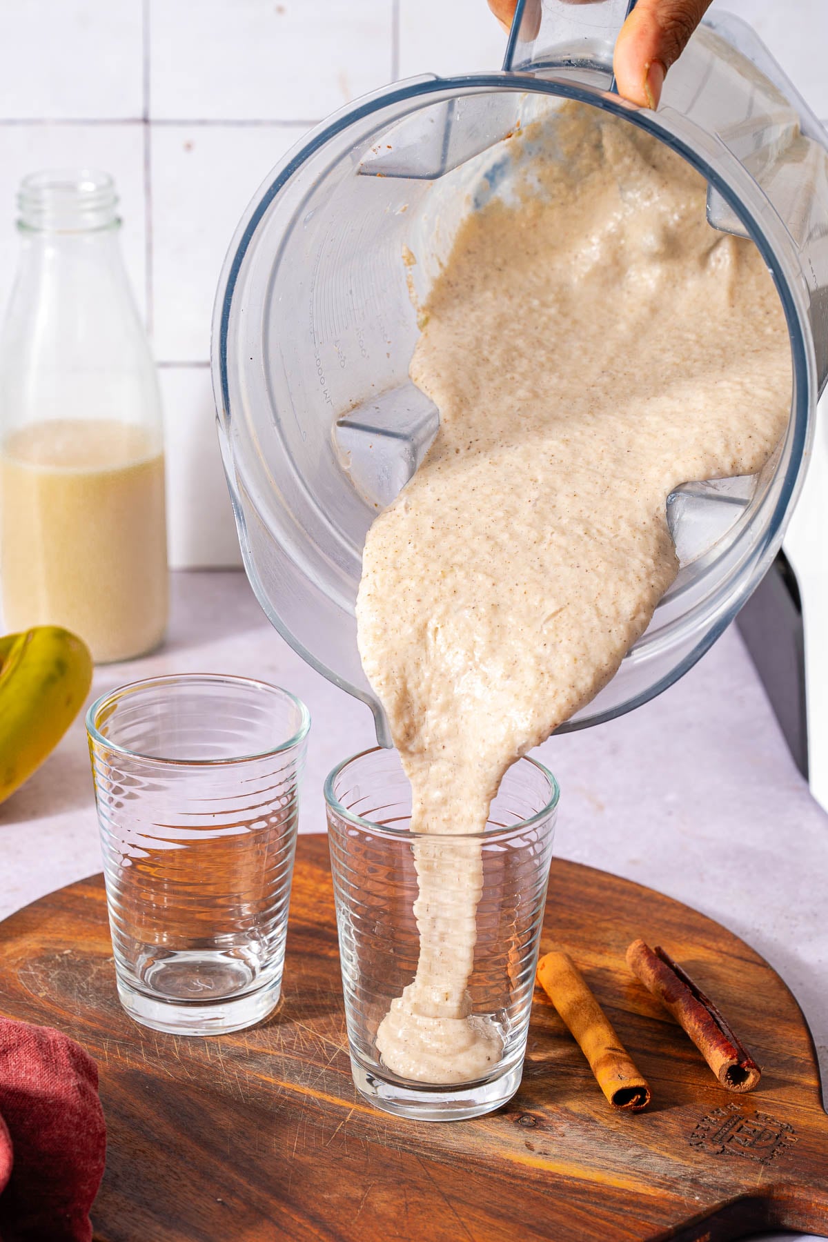 Pouring thick and creamy shake in a glass