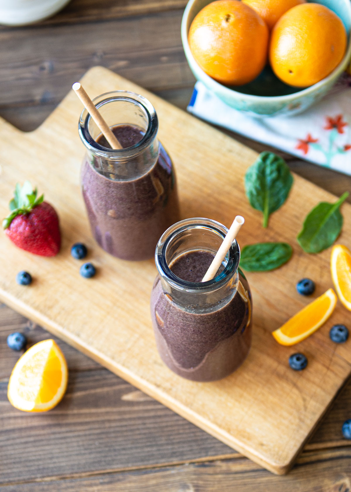 Berry smoothie in 2 glasses with paper straws.