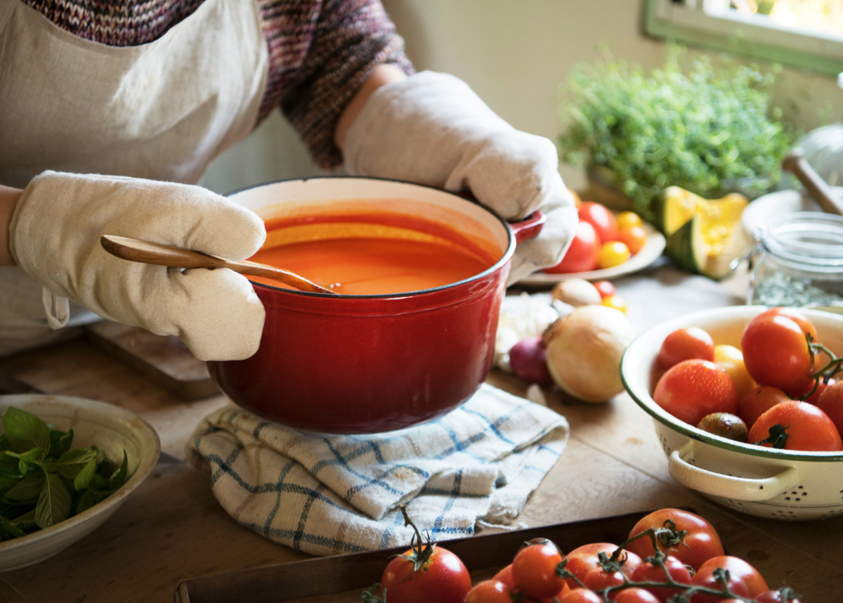 Person holding a pot of vegan soup ready to be served