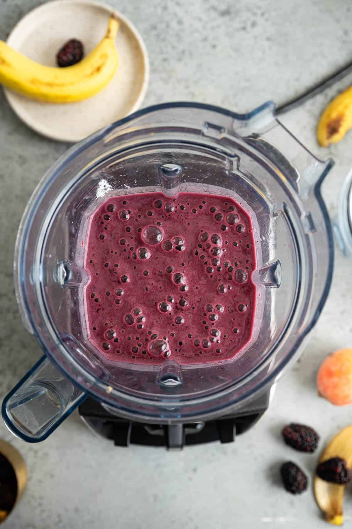 Blended blackberry peach smoothie in a blender
