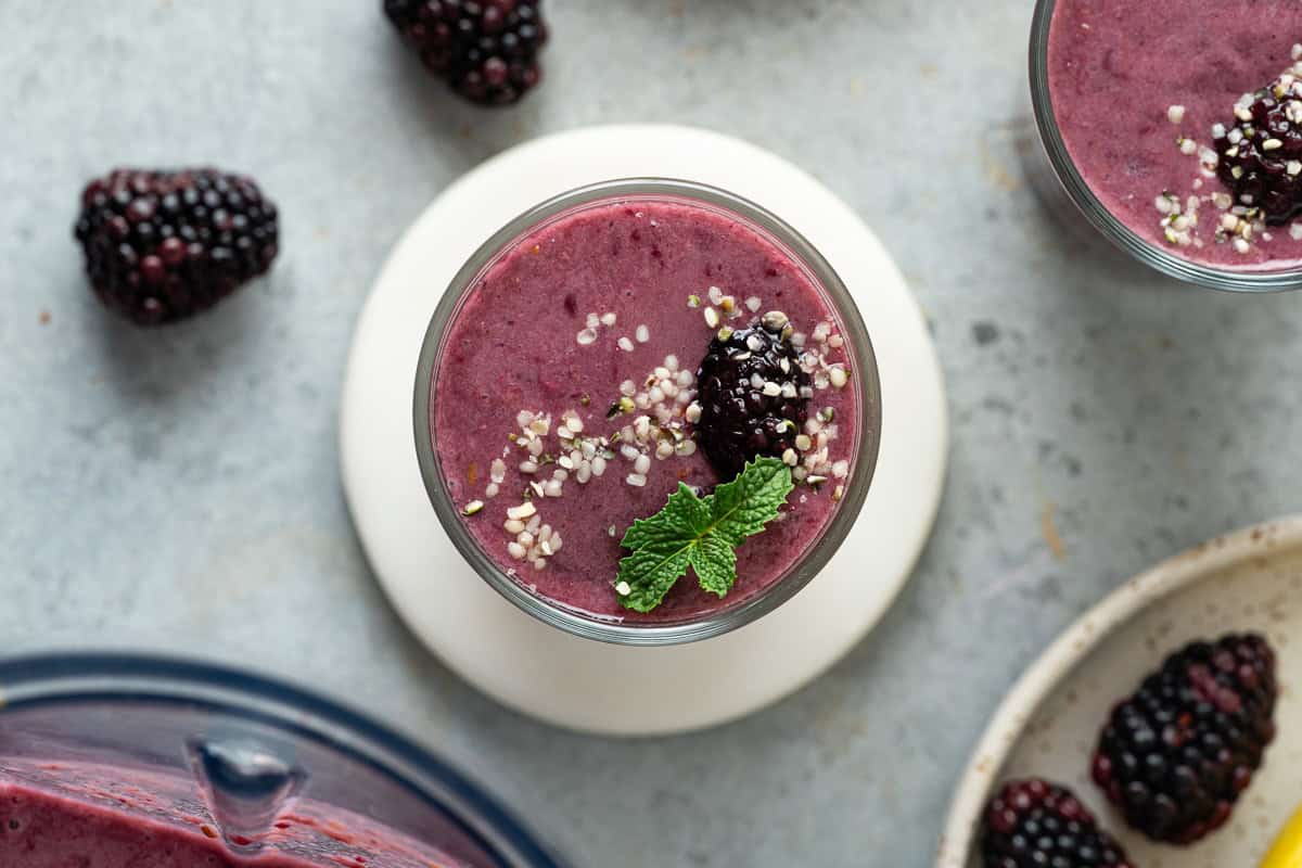 Deep purple blackberry peach smoothie ready to sip
