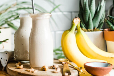 Breakfast banana smoothie in a glass with a metal straw for weight loss.