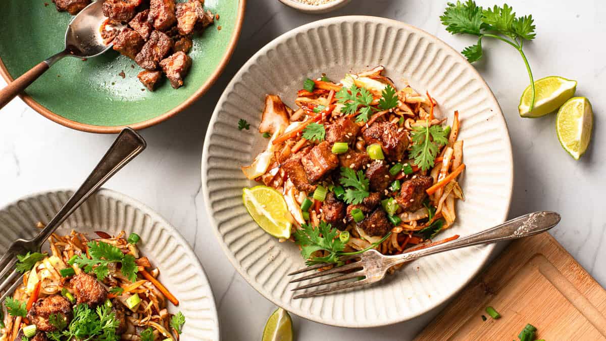 Two servings of cabbage stir fry topped with crispy tofu