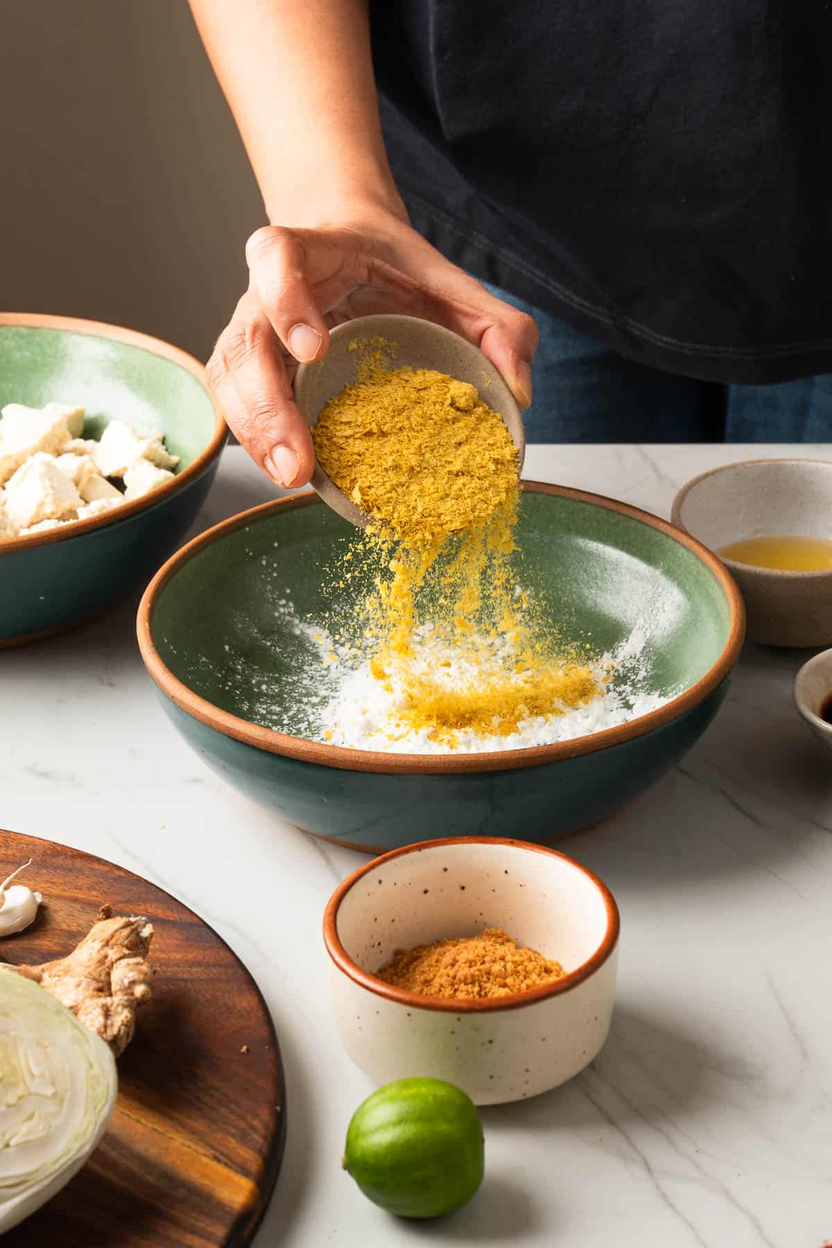 Mixing dry ingredients for crispy tofu in a small bowl