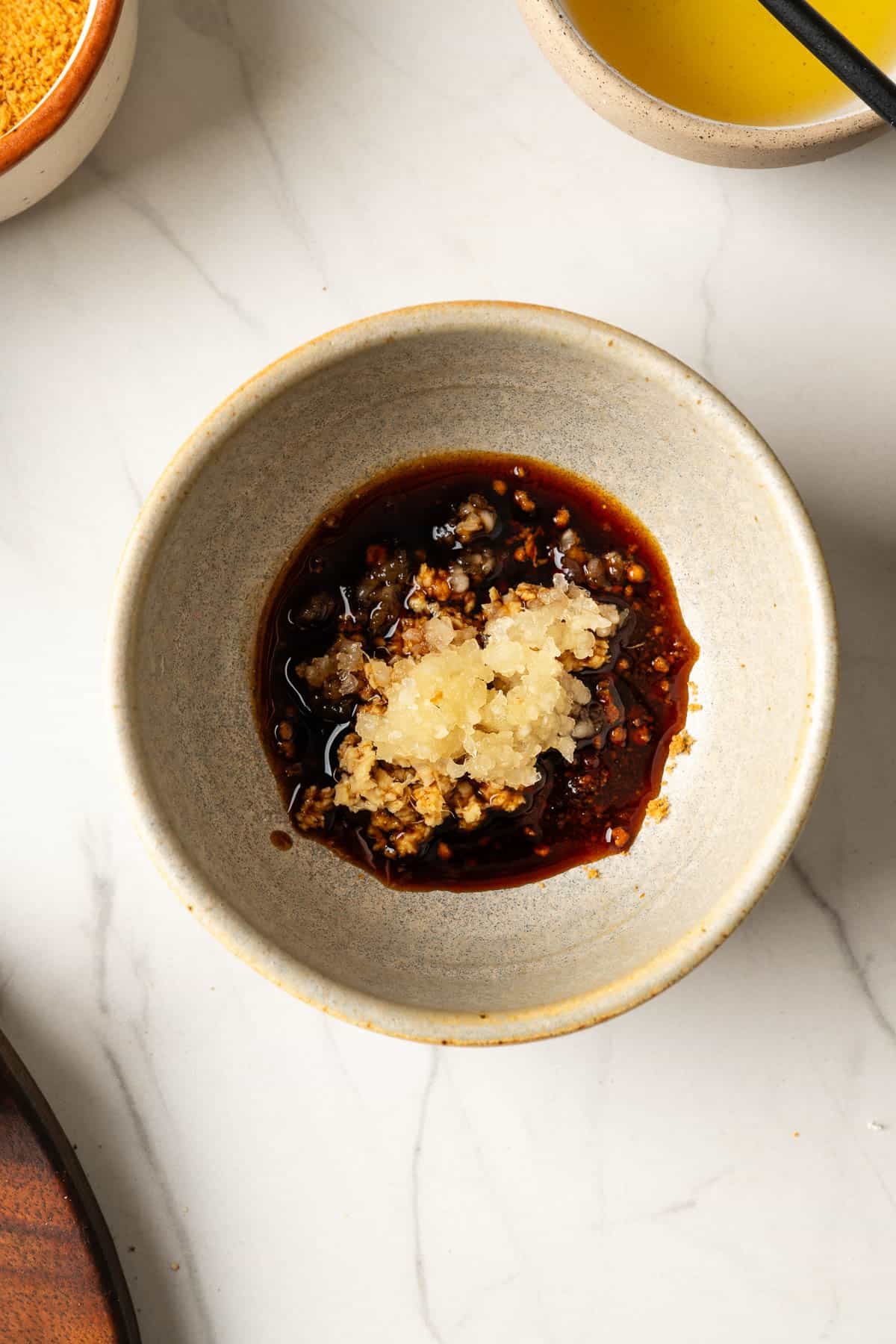 A small bowl containing tamari, coconut sugar, garlic, and ginger