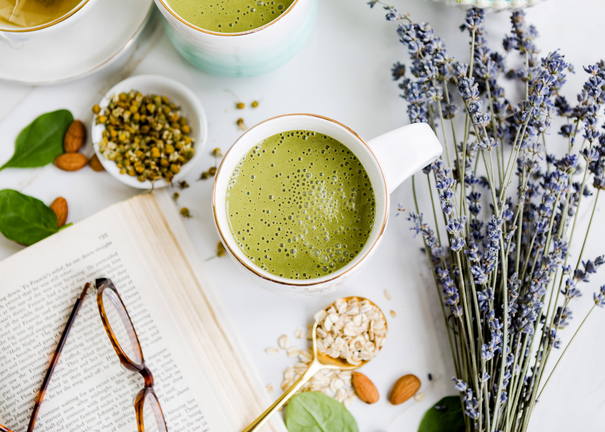 Nighttime smoothie in a white mug, surrounded by sleep-enhancing ingredients like lavender, oats, and chamomile for a restful sleep.