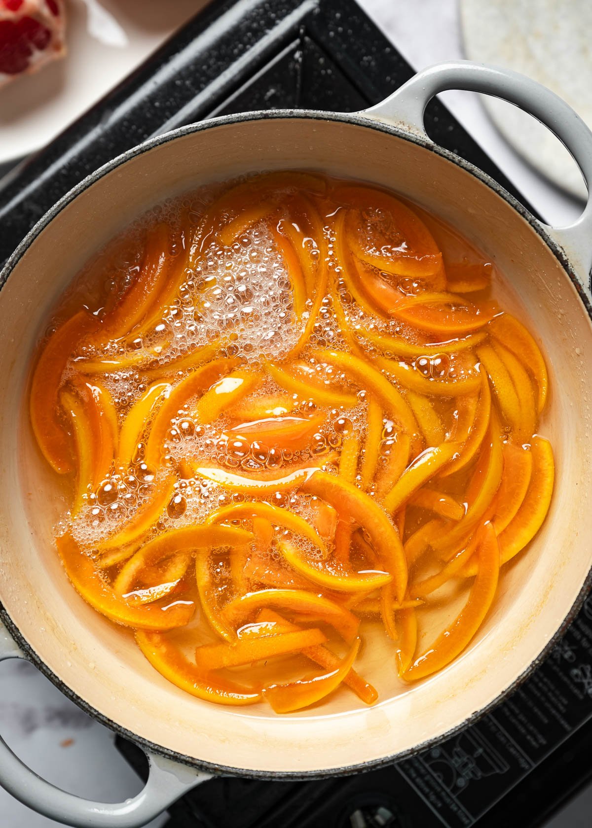 Grapefruit peel strips boiling in a pot of sugar syrup