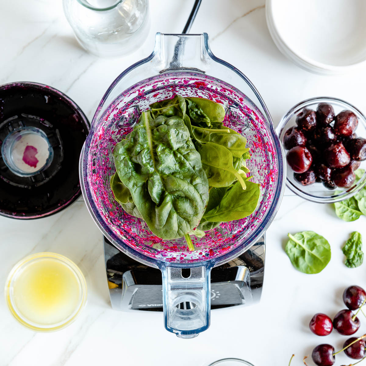 Top-down view of blender container filled with fresh spinach
