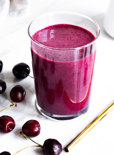 A close-up of a vibrant purple cherry collagen smoothie