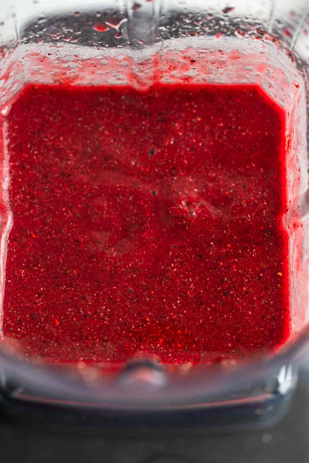 Bright red chia fruit smoothie in a blender