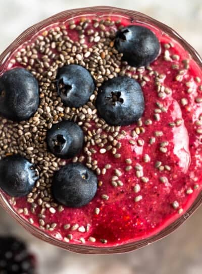 Chia fruit smoothie topped with blueberries and chia seeds in a glass