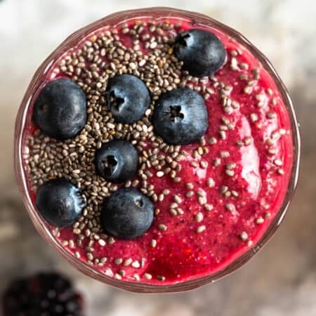 Chia fruit smoothie topped with blueberries and chia seeds in a glass