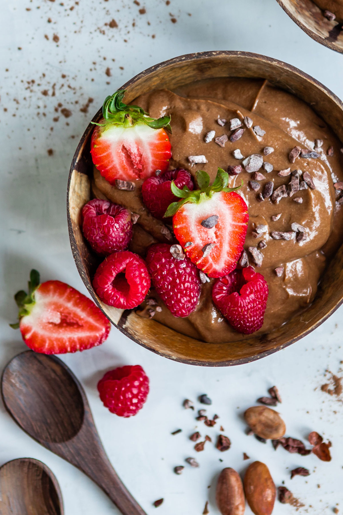 A delicious Chocolate smooth bowl topped with fresh strawberries, raspberries, chocolate pieces