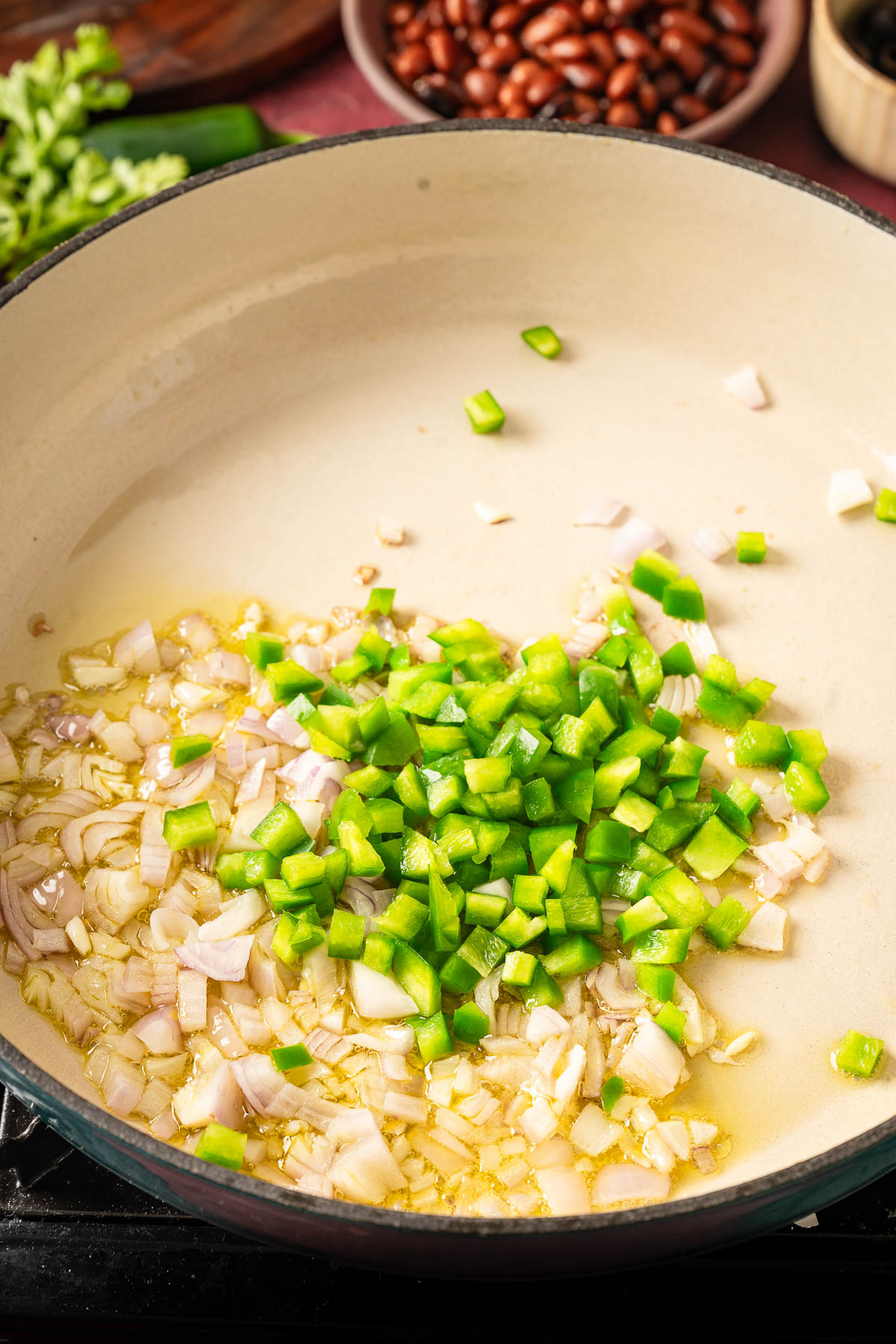 Chopped vegetables getting sautéed in a skillet