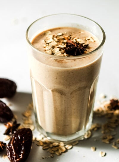 Glass of cinnamon date smoothie with medjool dates and oats on the table.