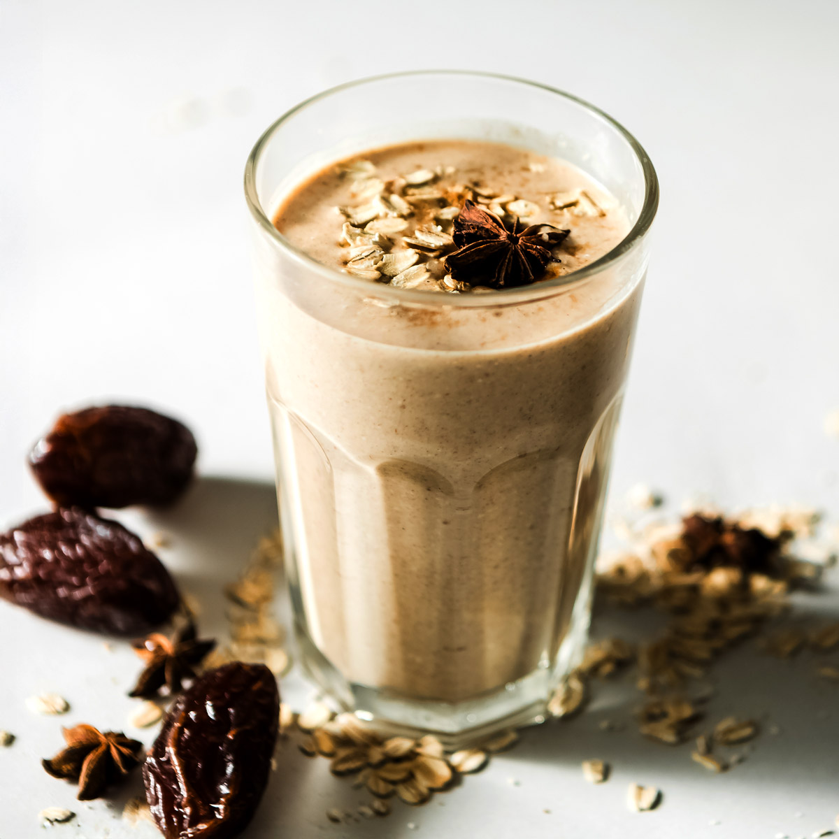 Glass of cinnamon date smoothie with medjool dates and oats on the table.