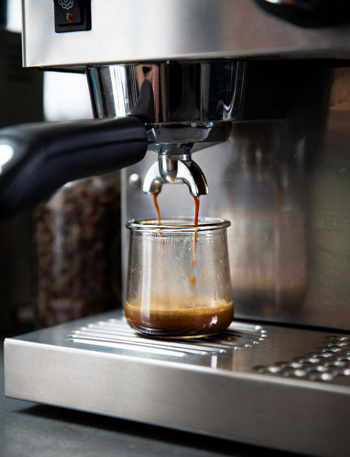 Espresso machine pulling a shot of espresso into a glass.