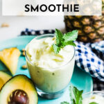 Fresh ingredients surround a glass of healthy avocado smoothie recipe on a plate.