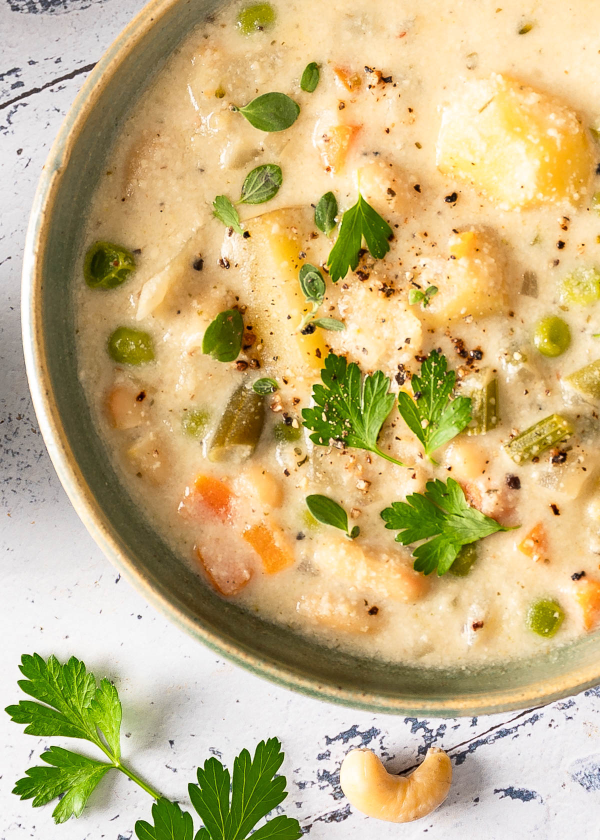 A detailed image of creamy vegetable soup garnished with fresh parsley