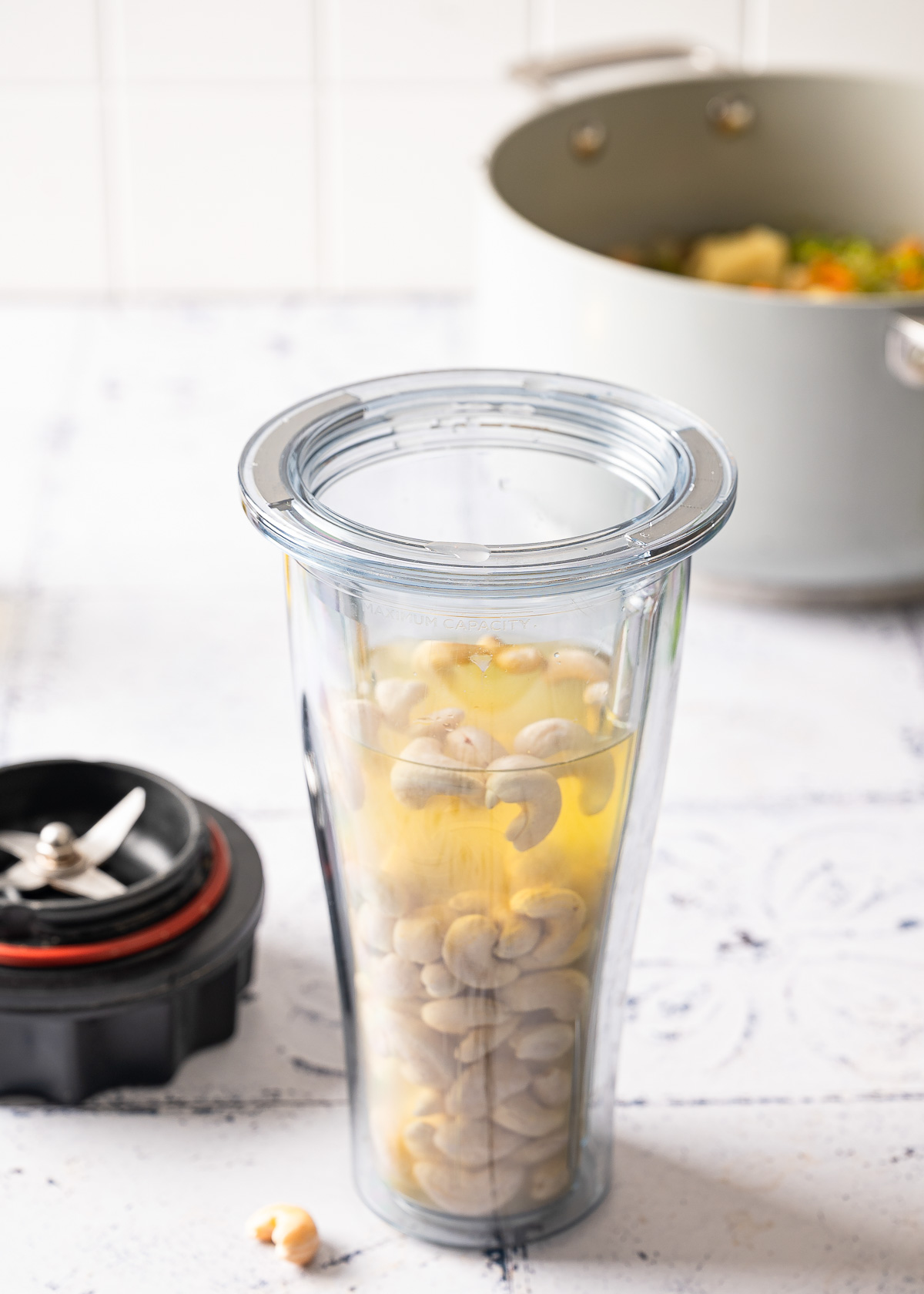 Cashews inside a blender container in preparation for blending.