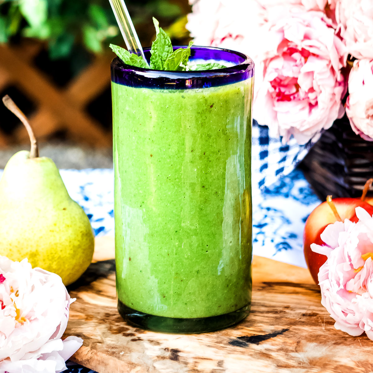 Glowing green smoothie recipe in a glass with straw