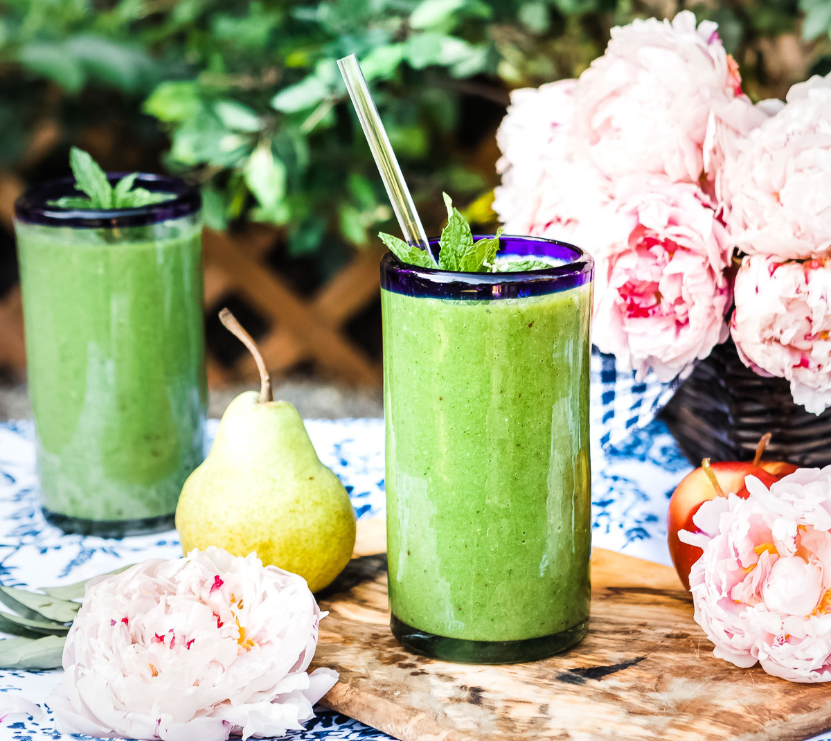 Two glasses of glowing green smoothie on a table